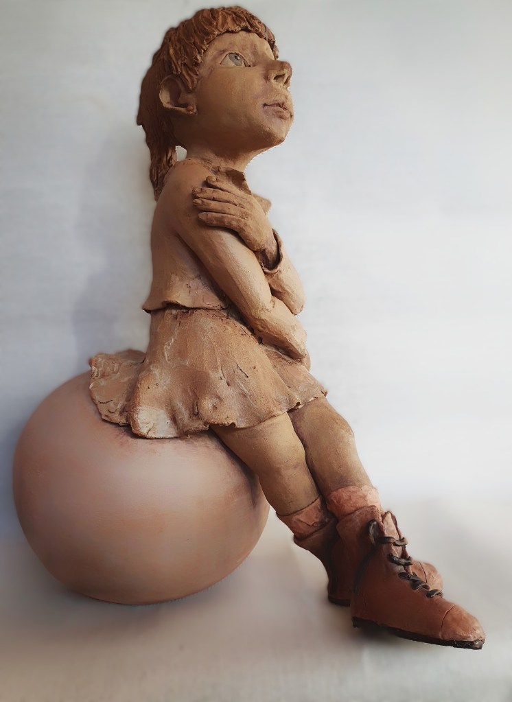 Meisje uit klei, steengoed gebakken op grote bal.